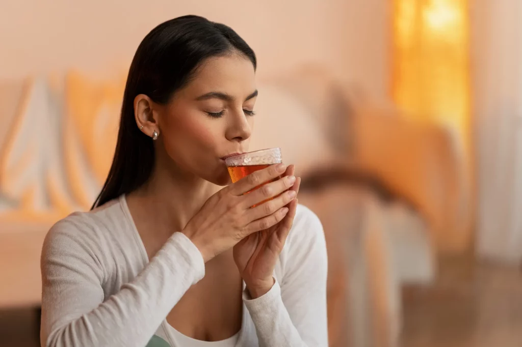 seorang wanita meminum teh untuk diare